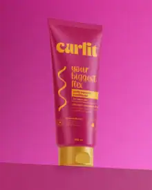 Vibrant pink Curlit leave-in conditioner tube with yellow cap, designed for wavy hair, promoting biggest flex, with silicone and paraben-free for moisturized, frizz-free, defined waves.
