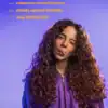 Twist-out curly hair natural hairstyle woman with long, voluminous curls wearing a purple hoodie smiling against purple background.