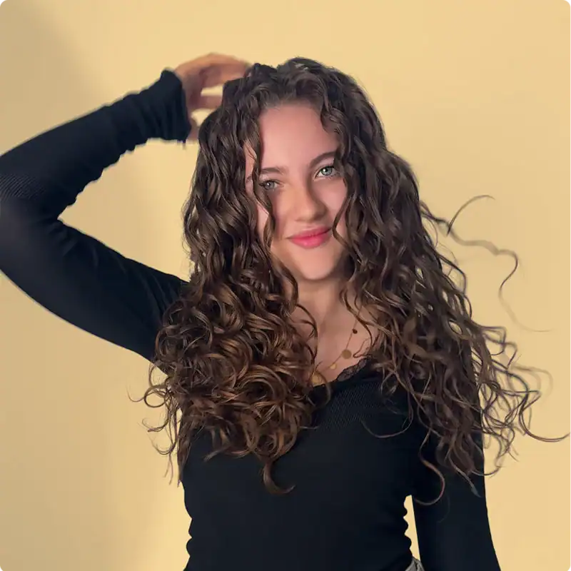 Lush curly hair with defined ringlets, showcasing a natural and voluminous hairstyle perfect for enhancing textured curls.