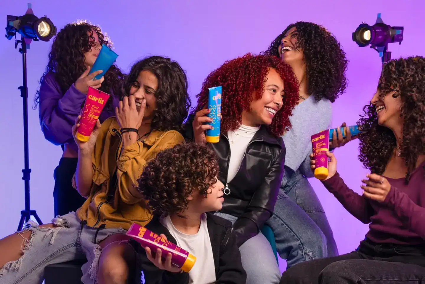 Moisturizing curl cream for textured hair, diverse group of friends with curly hair enjoying hair care products, vibrant lighting, and fun atmosphere, promoting healthy curls from Curlit.