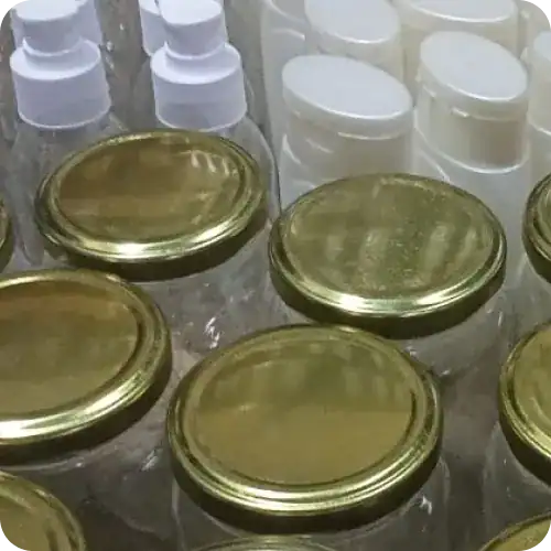 Gold cosmetic jars with white lids for skincare products.